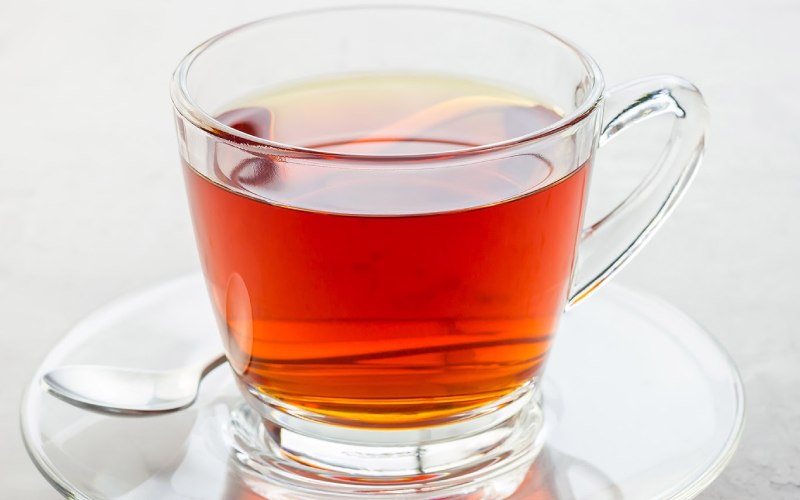 rooibos tea in glass cup and on glass saucer