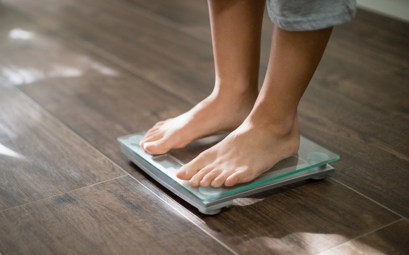 person standing on weight scale at home