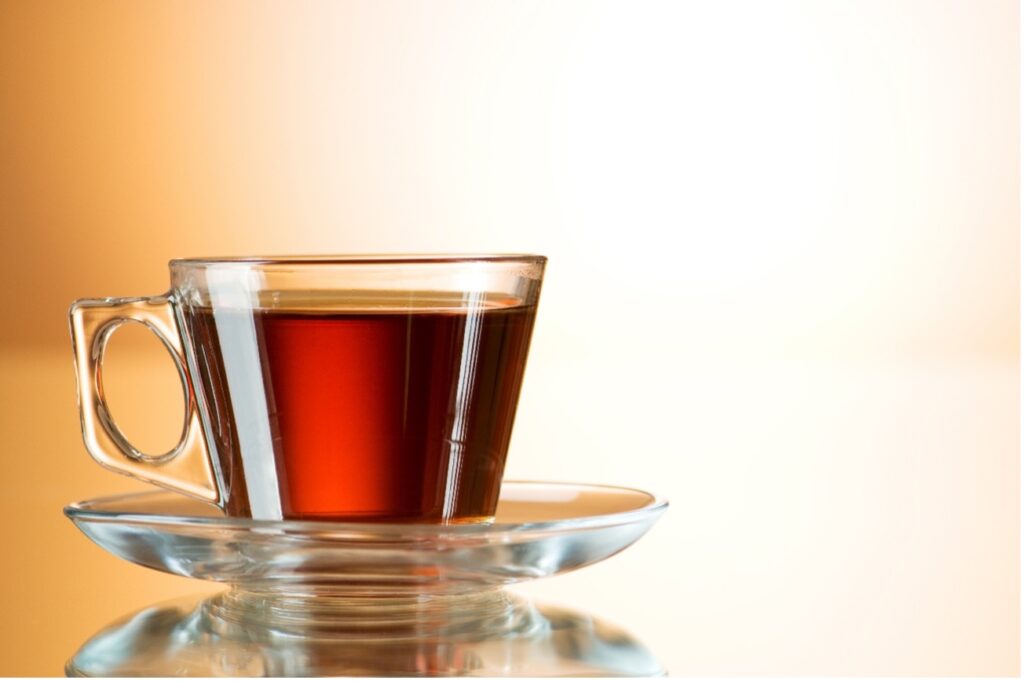 Rooibos tea in a clear glass mug on a saucer